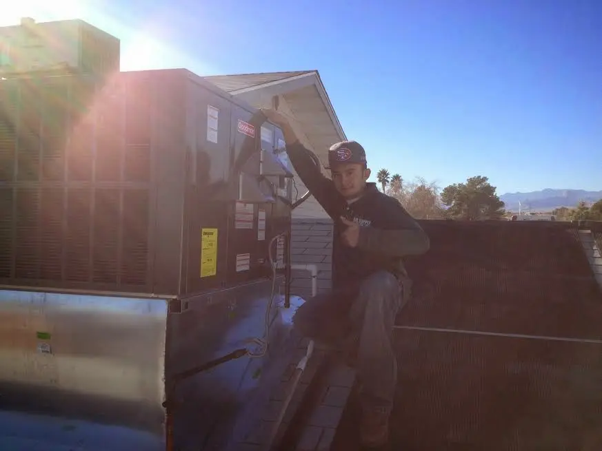 HVAC technician performing AC Tune-Up on a rooftop unit in Tallulah